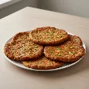 chapli-kababs-on-full-plate-with-background-environment_9e10aa45-df30-4fd0-a76e-3e5c3f9d9c68.webp